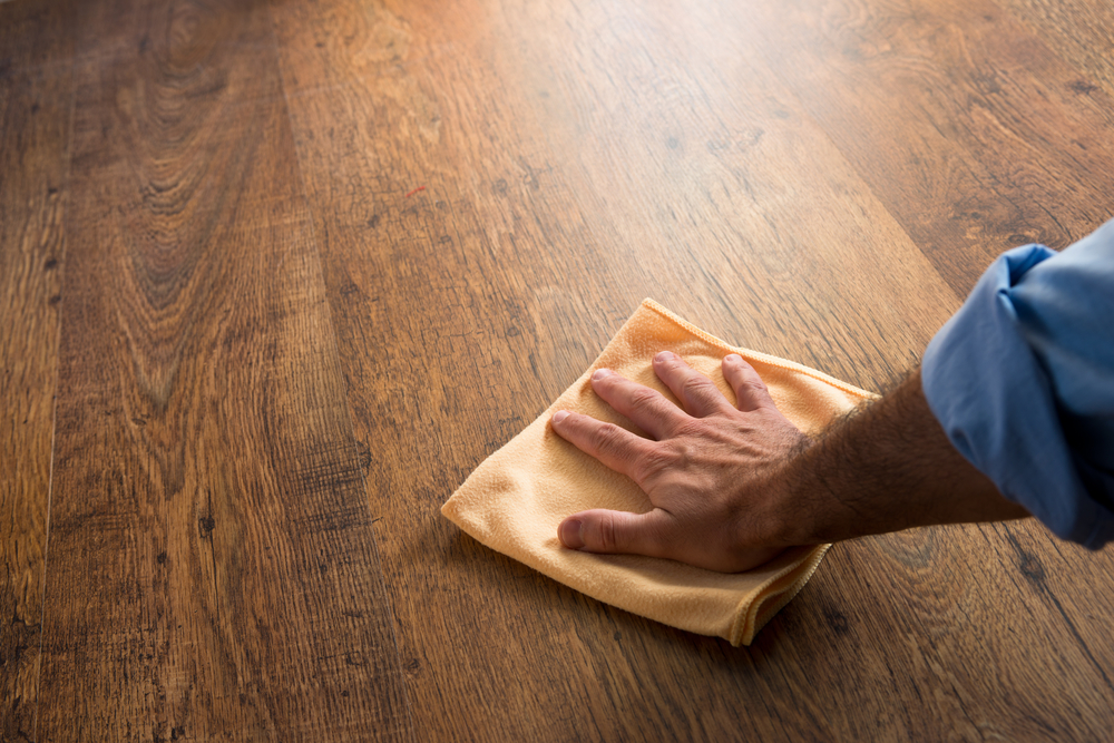 male hand cleaning hardwood floor