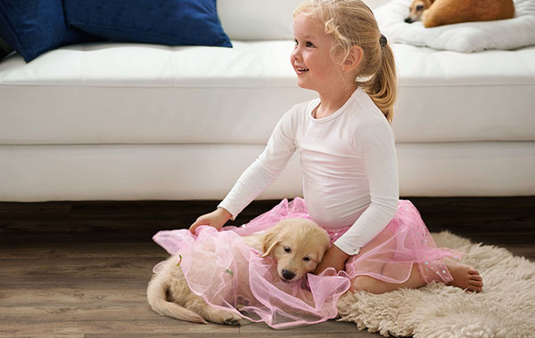 young girl and puppy both dressed in tutus sitting on Metroflor Genesis hardwood floors
